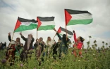 Des femmes brandissent des drapeaux palestiniens pendant une manifestation dans la bande de Gaza, près de la barrière de sécurité qui sépare l'enclave d'Israël, le 30 mars 2018