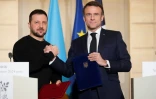 Le président français Emmanuel Macron (droite) et son homologue ukrainien Volodymyr Zelensky se serrent la main, le 16 février 2024 à Paris