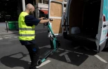 Un employé charge des scooters électriques dans une camionnette à Paris, le 23 août 2023