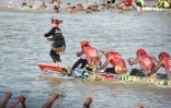 Rayyan Arkan Dikha danse à l'avant d'un bateau lors d'une course nautique traditionnelle, le 22 août 2025 sur la rivière Kuantan, dans la province indonésienne de Riau, sur l'île de Sumatra 
