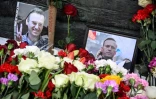 Des photos de l'opposant Alexeï Navalny sont exposées près de fleurs déposées au niveau du monument pour les victimes des répressions politiques, le 17 février 2024 à Moscou