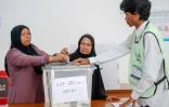Une femme aide sa mère âgée à voter dans un bureau de Malé, le 23 septembre 2018 aux Maldives