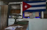 Une vieille balance sur le comptoir d'une épicerie à prix subventionnés, près d'un drapeau cubain et d'un portrait de Fidel Castro (1959-2006), le 5 octobre 2026 à La Havane, à Cuba