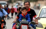 Un homme amène des enfants à l'école sur sa motocyclette, dans la ville de Qamichli, dans le nord-est de la Syrie, le 1er octobre 2018