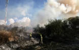 Des pompiers éteignent un feu à Lod, dans le centre d'Israël, causé par le tir d'un missile depuis le Yémen, le 15 septembre 2024, sur fond de guerre dans la bande de Gaza entre Israël et le Hamas palestinien