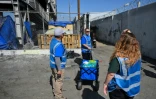 Armando Covarrubias (au centre) et ses collègues de l'association Hope The Mission distribuent de l'eau et de la nourriture dans un campement de sans-abris à Los Angeles, le 1er juin 2026