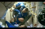 Le cosmonaute russe Mikhaïl Kornienko (haut) et l'astronaute américain Scott Kelly (bas) pénètrent dans la Station spatiale internationale (ISS), le 28 mars 2015 (capture d'écran NASA TV)