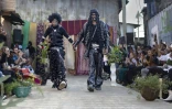 Le styliste Morgan Azedy présente avec un mannequin les tenues qu'il a créées à partir de tissus et de vêtements mis au rebut, lors du défilé de mode Gikomba Runway Edition à Nairobi, le 10 octobre 2025 au Kenya