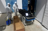 Sur cette photo d'archive prise le 04 juillet 2021, des employés de la municipalité tunisienne désinfectent le corps d'une victime du Covid-19 à l'hôpital Ibn al-Jazzar dans la ville de Kairouan, dans le centre-est de la Tunisie