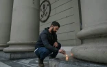 Un homme allume une bougie devant la cathédrale de Buenos Aires, le 21 avril 2025