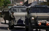 Des soldats israéliens à côté de véhicules blindés lors d'un raid militaire à Jénine, le 21 mai 2025 en Cisjordanie occupée