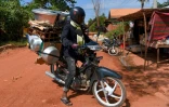 Un homme transporte à l'arrière de sa moto des chiens dans une cage placée sous des ustensiles de cuisine, qu'il va aller vendre aux abattoirs fournissant les restaurants, le 25 octobre 2019 dans la province de Siem Reap, au Cambodge