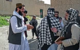 Ismail Ashuqullah, un kamikaze formé par les talibans, parle avec des agents du renseignement taliban après un entretien avec l'AFP dans le village d'Otarhi, le 25 mai 2023 dans la vallée de Tangi, en Afghanistan