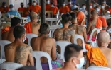 Des détenus attendent leur tour pour se faire enlever leurs tatouages marquant leur appartenance à un gang, le 23 novembre 2020 à la prison de New Bilibid, à Manille, aux Philippines