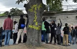 Des migrants font la queue pour recevoir de la nourriture, près du centre humanitaire pour migrants de la Porte de la Chapelle, dans le nord de Paris, le 27 juillet 2017