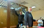 Oleg Orlov (g) porte une chaise à son procès à côté de son ami Dmitri Mouratov, dans un tribunal de Moscou, le 11 octobre 2023