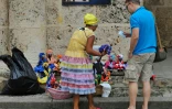 Un touriste achète un souvenir à une cubaine dans le quartier historique de La Havane, le 16 décembre 2015