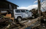 Une voiture au milieu de débris le 5 janvier 2024  à Shiromaru au Japon après un tsunami provoqué par le séisme du Nouvel An