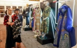 Des visiteurs regardent les créations présentées lors de l'exposition ayant lieu dans le cadre du festival national de la mode à Téhéran, et les vêtements conçus par de jeunes designers iraniens, le 21 janvier 2024