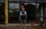 Un homme devant un magasin dévasté par les inondations meurtrières près d'Athènes