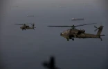 Photo diffusée le 18 avril 2026 par le commandement militaire américain pour le Moyen-Orient (Centcom), montrant des hélicoptères AH-64 volant au-dessus de détroit d'Ormuz