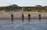 Des CRS arrivent sur la plage de Gravelines où des migrants tentent de monter à bord d'un bateau de passeurs pour traverser la Manche, le 16 juin 2025 dans le Nord