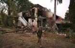 Un soldat israélien passe devant une maison détruite par des combattants palestiniens du Hamas le 7 octobre 2023 dans le kibboutz Beeri près de la frontière avec Gaza, le 11 octobre 2023