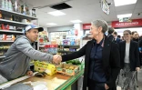 La Première ministre Elisabeth Borne (c) rencontre un commerçant lors d'une visite à Chanteloup-les-Vignes, le 27 octobre 2023 dans les Yvelines