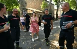 Une femme remercie les pompiers pour leur lutte contre les incendies à Tournissan, dans le sud de la France, le 10 août 2025