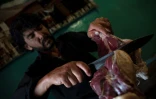Dans cette photo prise le 14 juin 2023, Waheed, un chef cuisinier afghan propriétaire d’un restaurant à Kaboul, découpe de la viande pour préparer un plat traditionnel appelé « chainaki », un ragoût d’agneau cuit dans des théières