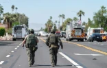 Deux démineurs marchent près de la scène de l'explosion d'une bombe qui a endommagé une clinique spécialisée dans la procréation médicalement assistée (PMA) et fait un mort, le 17 mai 2025 à Palm Springs, en Californie