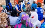 La directrice générale adjointe de l'Organisation internationale pour les migrations (OIM), SungAh Lee (d), s'entretient avec des Tchadiens de retour au pays à Adré, le 8 juin 2026 au Tchad