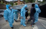 Des proches revêtus de combinaisons de protection portent le corps d'une victime du coronavirus lors de funérailles à Srinagar, Inde, le 7 mai 2021