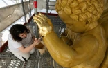 La restauratrice d'art Cyrielle D'Antoni travaille avec des feuilles d'or sur la statue de Jésus, à côté de la Vierge Marie, lors de la rénovation de la basilique Notre-Dame de la Garde à Marseille, le 3 septembre 2025