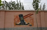 Une peinture murale de propagande montre un marteau écrasant des "terroristes" en juin 2019 à Kashgar, au Xinjiang
