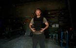 Andriï Paliy porte un gilet pare-balles  utilisant les plaques de métal qu'il a fabriquées dans un atelier de Zaporijjia, le 1er mai 2022 en Ukraine
