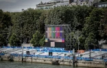 Cette photographie montre un écran géant et les tribunes sur la Seine à la veille de la cérémonie d'ouverture des Jeux olympiques 2024, à Paris, le 25 juillet 2024