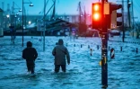 Des piétons se frayent un chemin dans une rue inondée après le passage de la tempête Babet, le 20 octobre 2023 à Flensburg dans le nord de l'Allemagne  