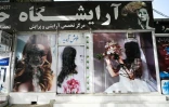 Des affiches de femmes recouvertes de peinture noire sur la devanture d'un salon de beauté, le 18 août 2021 à Kaboul, après la prise de la ville par les talibans