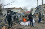 Oleg (C) et deux autres habitants de Jytomyr au milieu des décombres, le 2 mars 2022, après un bombardement russe sur cette ville située à l'ouest de Kiev, en Ukraine