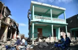 Peu de maisons ont résisté à Jeremie, dans l'ouest d'Haïti, où des hommes circulent à moto au milieu des ruines, le 7 octobre 2016