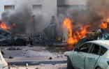 Des voitures en flammes, le 7 octobre 2023 à Ashkelon, dans le sud d'Israël, après des tirs de roquettes depuis la bande de Gaza