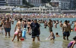 Des personnes se rafraîchissent dans l'eau à la plage de La Concha, dans la ville basque espagnole de Saint-Sébastien, le 21 juin 2026