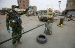 Un soldat irakien devant un barrage erigé à l'entrée du quartier de Sadr City, à Bagdad, le 28 mars 2020