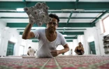 Un employé travaille sur une pièce d'étoffe imprimée à la planche dans l'atelier de la créatrice Brigitte Singh, le 2 juin 2022 à Amber, dans l'Etat du Rajasthan, en Inde