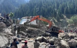 Des habitants déblaient les décombres de boutiques détruites par des crues soudaines à Parun, dans la province du Nouristan, le 21 juillet 2026 en Afghanistan
