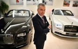 Le directeur général de Rolls-Royce, Torsten Müller-Ötvös pose entre un modèle de Rolls-Royce Dawn (g) un modèle Wraith Black Badge (d) dans le showroom du centre de Londres le 9 janvier 2019 2019