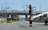 Des employés municipaux à Kiev réparent des lignes électriques après une attaque de missiles russes le 29 mai 2023
