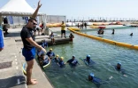 Des mères des quartiers Nord de Marseille écoutent un maître-nageur lors d'un cours de natation dispensé par l'association "Le Grand Bleu" dans une piscine d'eau de mer près du port de l'Estaque, le 11 août 2025