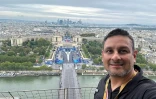 Le photographe de l'Agence France-Presse Luis Robayo prend un selfie depuis la tour Eiffel avant la cérémonie d'ouverture des JO, le 26 juillet 2024 à Paris